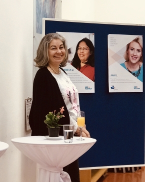 Lächelnde Dame steht vor einer Pinwand mit Plakaten. ABZ*AUSTRIA Fünf Jahre ABZ*Frauenberufszentrum Wien